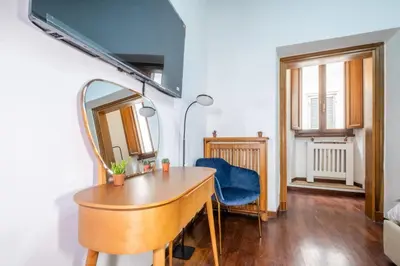 a room with a table and a mirror and a blue chair at Trevi Guesthouse in Rome