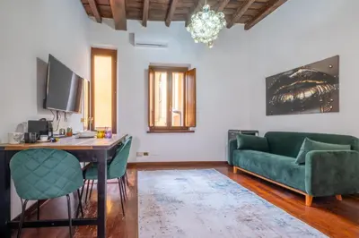 a living room with a table and green chairs at Trevi Guesthouse in Rome