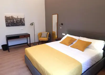 a bedroom with a large bed with yellow pillows at Domus Quintili Monti in Rome