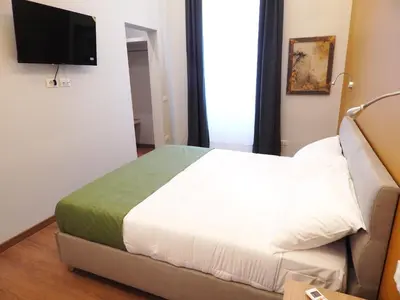 a bedroom with a bed and a flat screen tv at Domus Quintili Monti in Rome