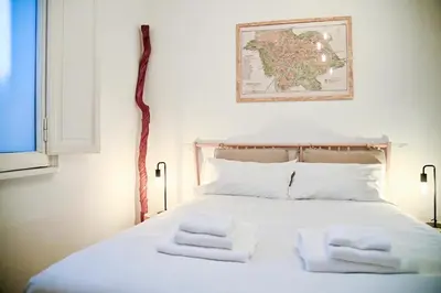 a bedroom with a white bed with a map on the wall at Why Not Apartment in Rome