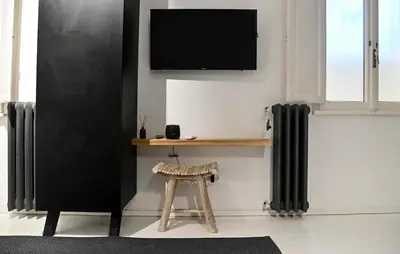 a living room with a tv and a stool at Why Not Apartment in Rome