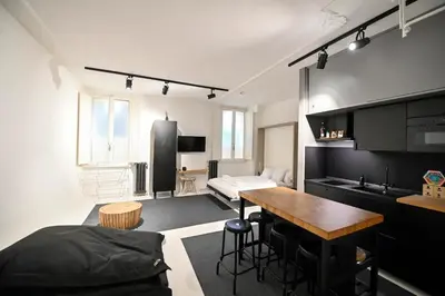 a kitchen and living room with a table and a bed at Why Not Apartment in Rome