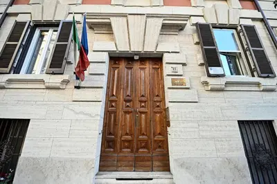 a building with a wooden door and a flag at Why Not Apartment in Rome