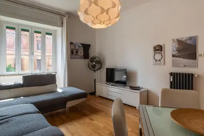 a living room with a couch and a tv at GuestHost - Bright Flat in Lungotevere Flaminio in Rome