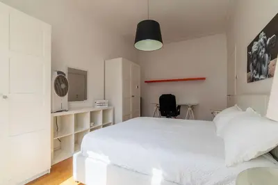 a bedroom with a large white bed and a desk at GuestHost - Bright Flat in Lungotevere Flaminio in Rome