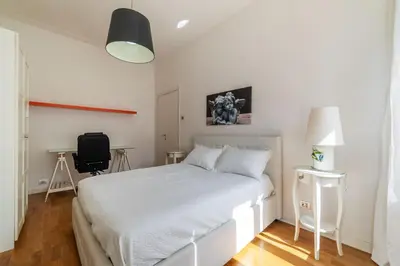 a bedroom with a white bed and a desk at GuestHost - Bright Flat in Lungotevere Flaminio in Rome