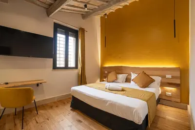 a bedroom with a large bed with a yellow wall at Terrace 34 in Rome