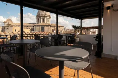 a balcony with tables and chairs with a view of a church at Terrace 34 in Rome