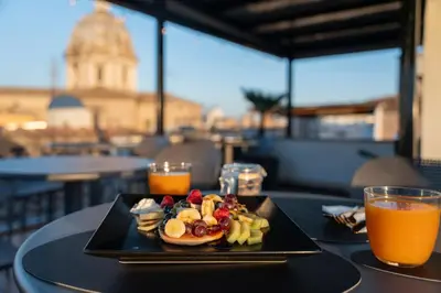 a plate of breakfast food on a table with orange juice at Terrace 34 in Rome