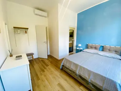 a bedroom with a bed with a blue wall at Domus 14 in Rome