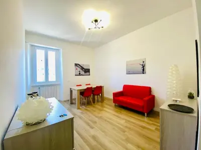 a living room with a red chair and a table at Domus 14 in Rome