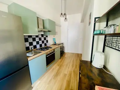 a kitchen with green cabinets and a wooden floor at Domus 14 in Rome