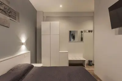 a white bedroom with a bed and a mirror at GuestHost - Metro Cipro Lovely Apartment X6 in Rome