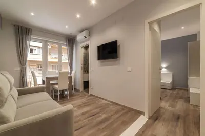 a living room with a couch and a television and a table at GuestHost - Metro Cipro Lovely Apartment X6 in Rome