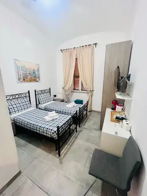 a living room with two beds and a chair at Grandis Rooms in Rome