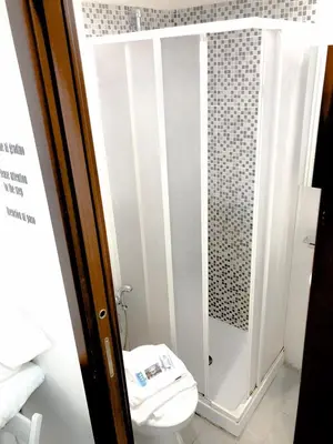 a small bathroom with a toilet and a shower at Grandis Rooms in Rome