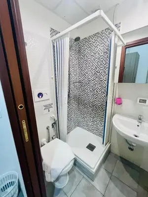 a bathroom with a shower and a toilet and a sink at Grandis Rooms in Rome