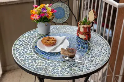 a glass table with a plate of cookies and flowers at Vatican Shabby apartment double bedrooms in Rome