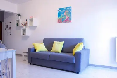 a blue couch with two yellow pillows in a living room at Nala's Vatican House in Rome