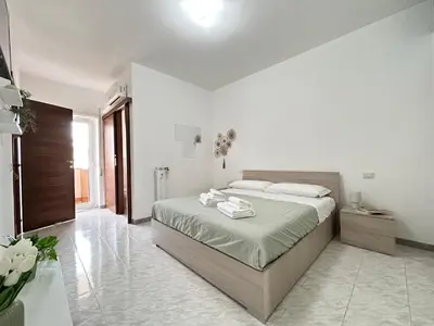 a bedroom with a large bed with white walls at Nala's Vatican House in Rome