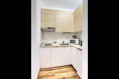 a small kitchen with white cabinets and a microwave at La Dimora di Piazza Navona in Rome