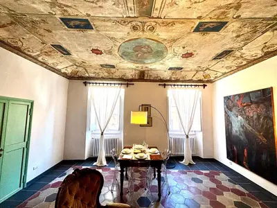 a room with a ceiling with a painting and a table at Atelier ed Affreschi a Campo de Fiori in Rome