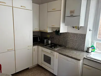 a kitchen with white cabinets and a stove top oven at Atelier ed Affreschi a Campo de Fiori in Rome