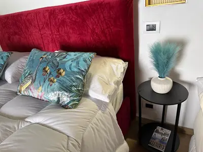a couch with a red headboard with a pillow on it at Suite at the Coliseum in Rome
