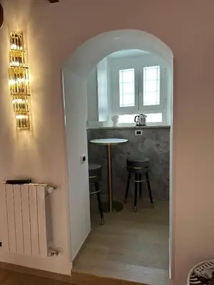 an archway leading into a kitchen with a table and stool at Suite at the Coliseum in Rome