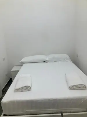 a white bed with white sheets and towels on it at Principe Umberto piano terra in Rome
