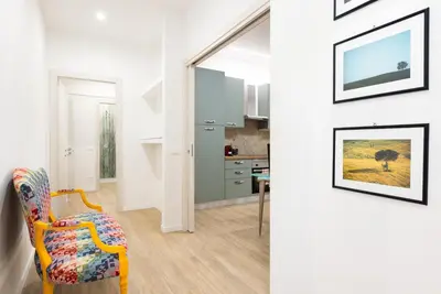 a living room with a yellow chair and a kitchen at Aventino Urban Place by One Up Hospitality in Rome