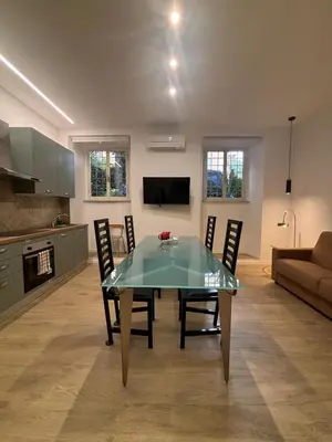 a dining room and kitchen with a glass table and chairs at Aventino Urban Place by One Up Hospitality in Rome