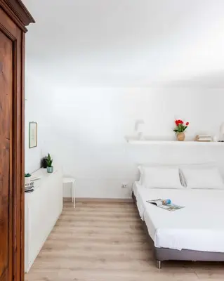 a white bedroom with a bed and a desk at Mini apartment Cairoli 1 - Zeno 42 in Rome