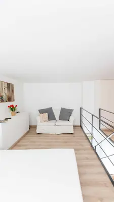a white living room with a couch and a staircase at Mini apartment Cairoli 2 - Zeno 42 in Rome