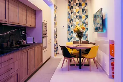 a kitchen with a table with chairs and a vase of flowers at 30' Walk Vatican & Stadium Art, Smart Home in Rome