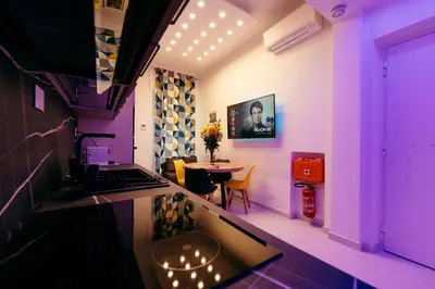 a purple room with a table and a laptop on a counter at 30' Walk Vatican & Stadium Art, Smart Home in Rome