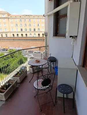 a balcony with two tables and chairs and a table at Suite Laterani 3 bedrooms with parking in Rome