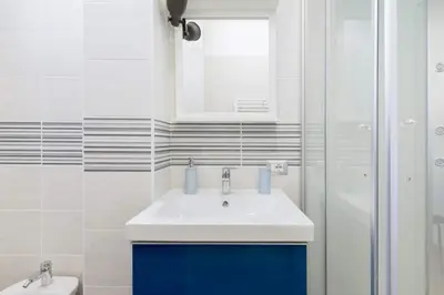 a white bathroom with a sink and a shower at Suite Laterani 3 bedrooms with parking in Rome