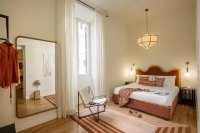 a bedroom with a large bed and a mirror at Domus Regia - Luxury Experience in Rome