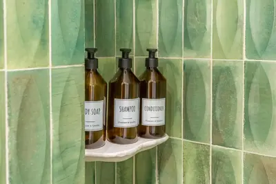 three bottles of wine on a shelf on a wall at Domus Regia - Luxury Experience in Rome