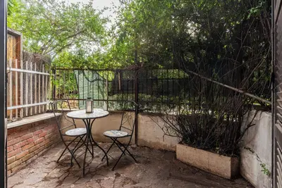 a patio with a table and chairs and a fence at GuestHost - Comfy Apartment near Vatican City! in Rome