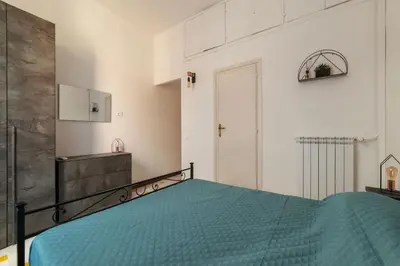 a bedroom with a bed with a blue comforter at GuestHost - Comfy Apartment near Vatican City! in Rome