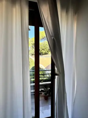 a view from a window with curtains open at Raffaella Vatican House in Rome