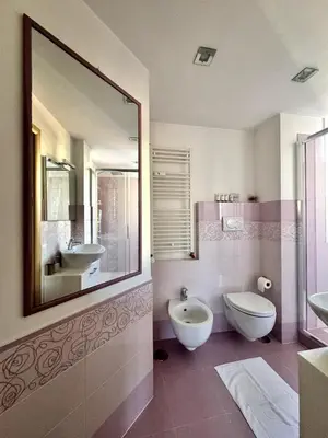 a bathroom with two sinks and a toilet and a mirror at Raffaella Vatican House in Rome