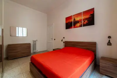 a bedroom with a bed with a red bedspread at GuestHost - Piazzale Clodio Apartment in Rome