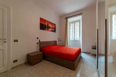 a bedroom with a bed with a red bedspread at GuestHost - Piazzale Clodio Apartment in Rome