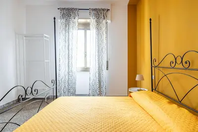 a bedroom with a bed with a yellow wall at Three large bedrooms for six people Rome downtown apartment in Rome
