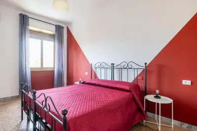 a red bedroom with a bed with a red bedspread at Three large bedrooms for six people Rome downtown apartment in Rome
