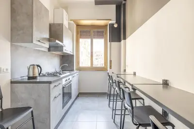 a kitchen with a counter and chairs in it at Three large bedrooms for six people Rome downtown apartment in Rome